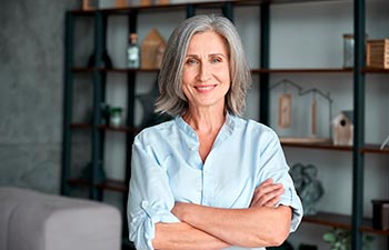 Smiling confident stylish mature middle aged woman standing at home office
