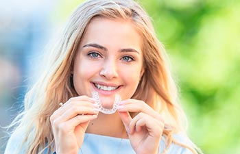 a young woman holding invisalign braces