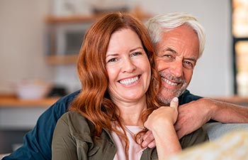 Portrait of middle aged couple hugging and looking at camera