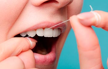 Smiling women use dental floss