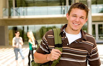 Young man at school holding a book bag