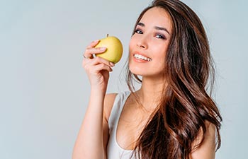 a young woman holding an apple